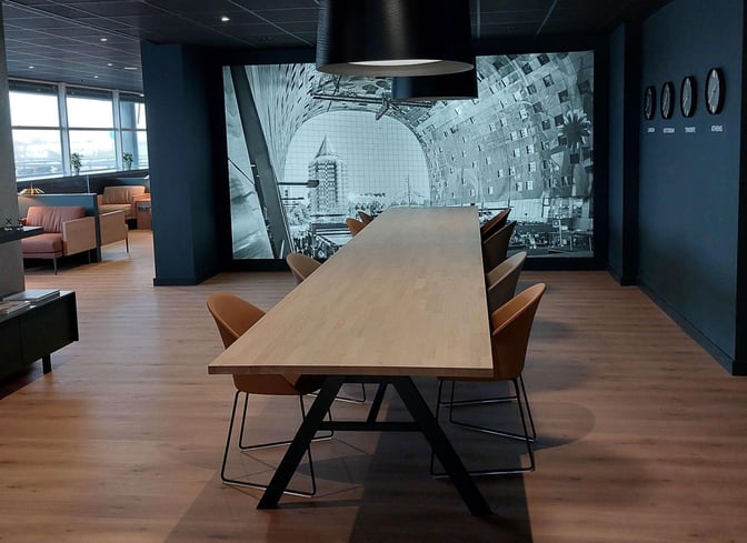 The Prima Vista Lounge at Rotterdam The Hague Airport features a long communal table with chairs, suitable for group seating or work.