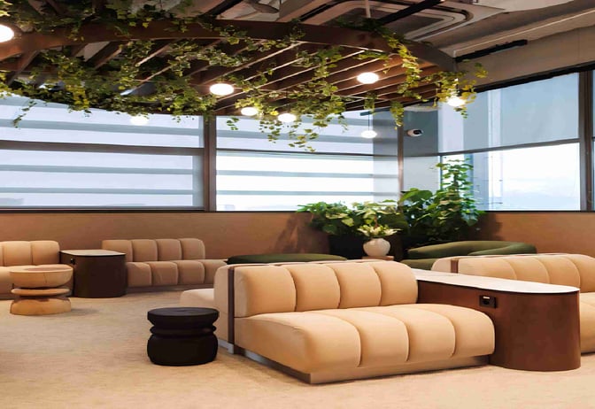 The seating area in the Business Lounge by Baltona at Rzeszów–Jasionka Airport features comfortable chairs and tables with surrounding greenery.