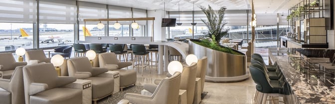 The Plaza Premium Bosphorus Lounge at Sabiha Gokcen International Airport features comfortable seating with tarmac views and a bar area for refreshments.