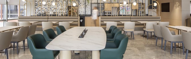 The Plaza Premium Bosphorus Lounge at Sabiha Gokcen Airport features spacious seating with tables and booth-style arrangements for dining and relaxation.