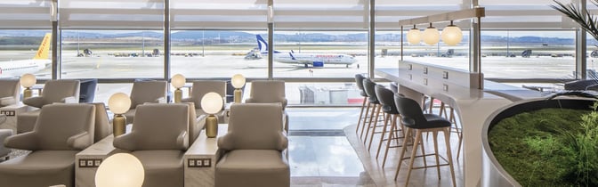 The Plaza Premium Bosphorus Lounge at Sabiha Gokcen Airport features seating with tarmac views and a counter area with barstools.
