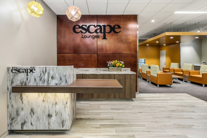 The entrance to the Escape Lounge at Sacramento International Airport features a reception desk and visible seating area in the background.