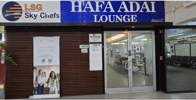 The entrance to the Hafa Adai Lounge at Saipan International Airport features glass doors and a welcome sign for members.