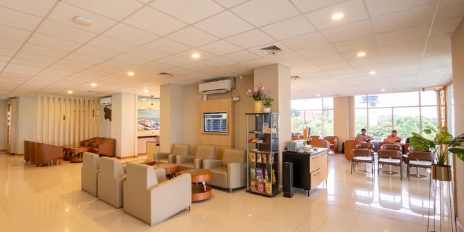 The Concordia Lounge at Sam Ratulangi International Airport features comfortable seating, a flight information display, and a snack area for travelers.