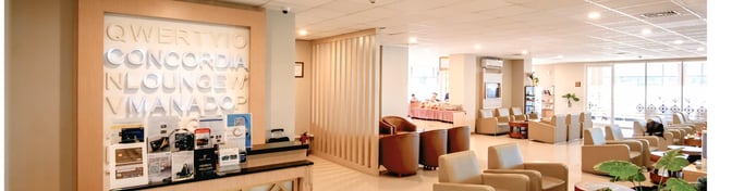 The Concordia Lounge at Sam Ratulangi International Airport features a seating area with armchairs and a reception desk displaying promotional materials.