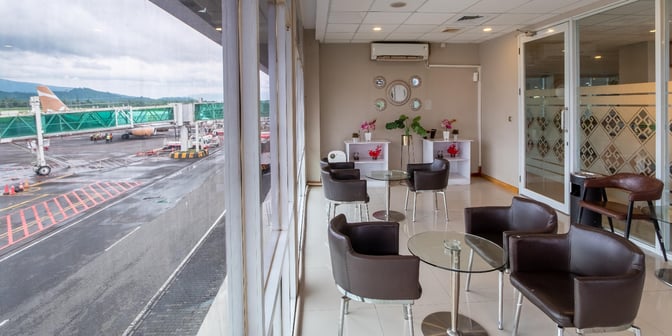 The Concordia Lounge at Sam Ratulangi International Airport features seating with tarmac views, offering a comfortable waiting area for travelers.
