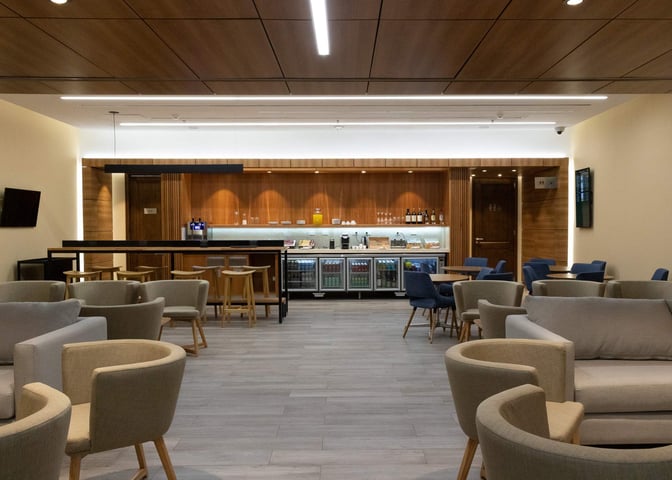 The lounge at San Carlos de Bariloche Airport features a bar area with seating, offering beverages and snacks for travelers.