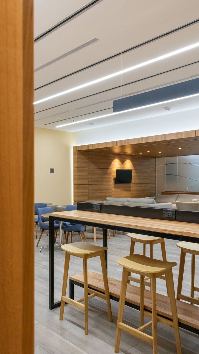 The lounge at San Carlos de Bariloche Airport features a seating area with stools and tables, providing a comfortable waiting space.