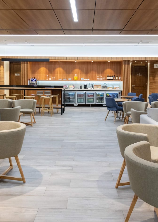 The lounge at San Carlos de Bariloche Airport features a self-serve bar area with seating and a variety of refreshments.