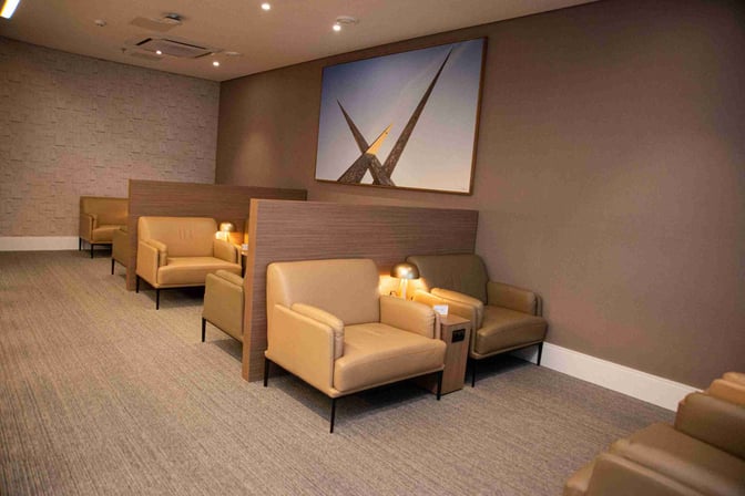 The seating area at W Lounge Goiânia features individual armchairs with side tables and lamps, providing semi-private spaces for travelers.