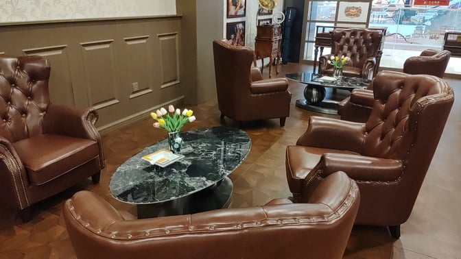 The seating area in the Cuba Pavilion Lounge at Sanya Phoenix International Airport features comfortable armchairs and marble tables for relaxation.