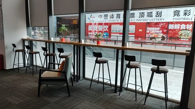 High stools and a counter provide seating with views of the concourse at the FLYVIP Lounge in Sanya Phoenix International Airport.