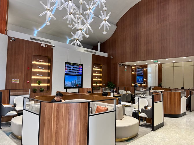 The V3 First Class Lounge at Sanya Phoenix International Airport features semi-private seating areas with flight information displays for travelers.