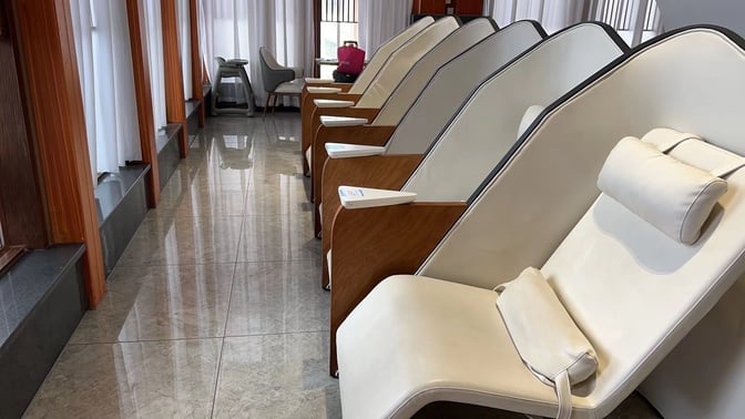 Reclining chairs in the V3 First Class Lounge at Sanya Phoenix International Airport offer a comfortable seating area for relaxation.