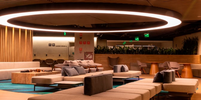 The seating area in the Plaza Premium Lounge at São Paulo–Guarulhos International Airport features comfortable couches and chairs for relaxation.