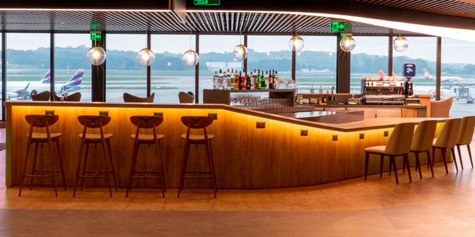 The bar at Plaza Premium Lounge in Sao Paulo–Guarulhos International Airport offers a selection of spirits and seating with runway views.