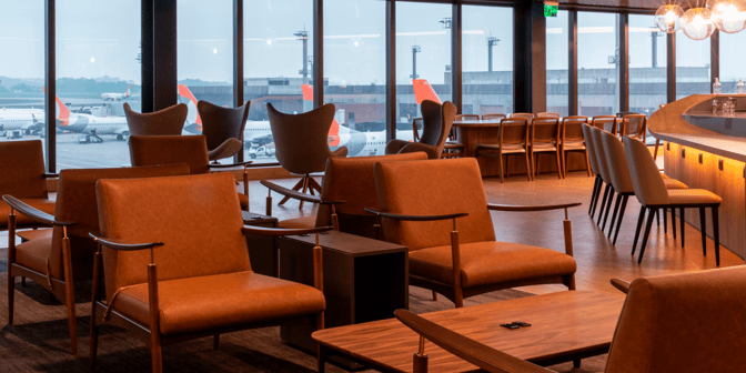The seating area in Plaza Premium Lounge at São Paulo–Guarulhos International Airport offers comfortable chairs with views of the runway.