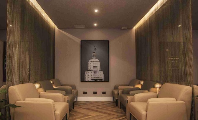 Seating area at W Lounge Guarulhos features comfortable armchairs arranged along the walls, providing a relaxing space for travelers.