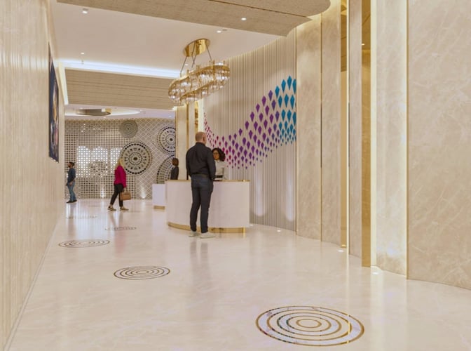 The reception area of the Adani Lounge at Sardar Vallabhbhai Patel International Airport features a check-in desk and decorative wall patterns.