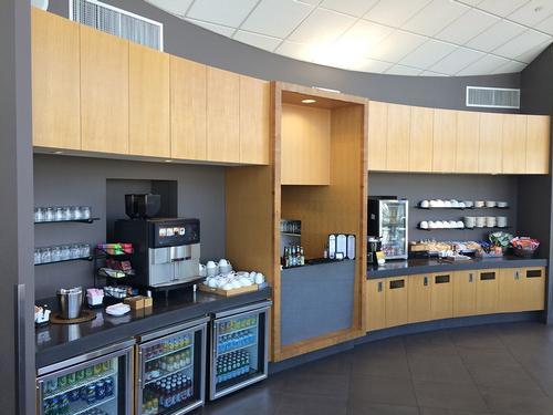 The Club SEA at Seattle-Tacoma International Airport features a self-serve beverage and snack station with coffee machines and refrigerated drinks.