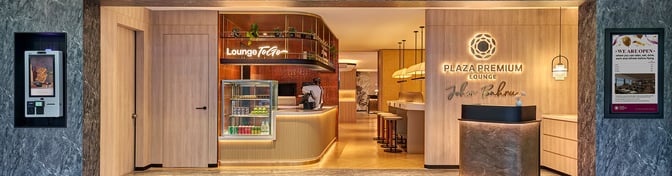 The entrance to the Plaza Premium Lounge at Senai International Airport features a reception desk and a "Lounge To Go" snack area.
