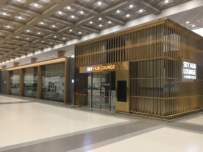 The Sky Hub Lounge entrance at Gimpo International Airport features a prominent sign and is located in a spacious terminal area.