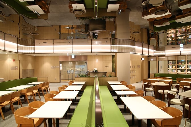 The Sky Hub Lounge East T2 at Seoul Incheon International Airport features communal tables and booth seating for dining and relaxation.