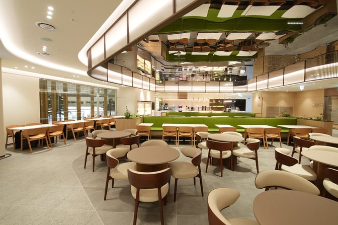 The Sky Hub Lounge East T2 at Seoul Incheon International Airport features a spacious seating area with tables and chairs for dining.