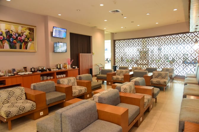 The Concordia Lounge at Sultan Aji Muhammad Sulaiman Sepinggan International Airport features comfortable seating and a self-serve food area with flight information screens.
