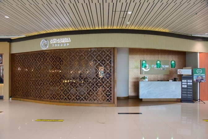 The entrance to Concordia Lounge at Sultan Aji Muhammad Sulaiman Sepinggan International Airport features a reception desk and decorative paneling.