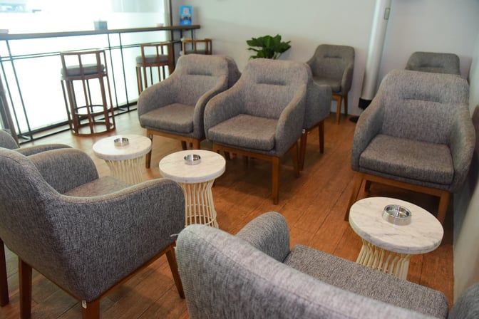 The seating area in Concordia Lounge features comfortable armchairs and small tables, providing a relaxing space for travelers.