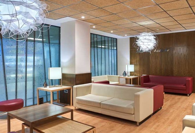 The Sala VIP Azahar at Seville Airport features a seating area with sofas and tables, providing a comfortable waiting space.