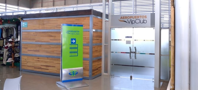 The entrance to the Aeropuertos VIP Club at Seymour Airport features frosted glass doors and directional signage for visitors.