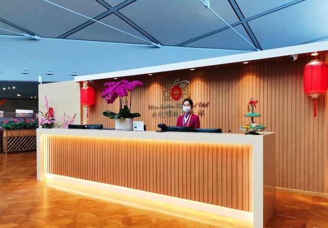 The reception area of the China Southern Sky Pearl Lounge at Shanghai Hongqiao International Airport features a staffed check-in desk and decorative elements.