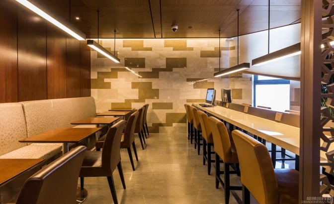 The lounge at Shanghai Hongqiao International Airport features booth seating and a counter with computers for passenger use.
