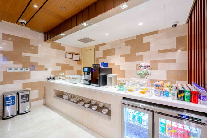 The self-serve food area at Shanghai Hongqiao International Airport's lounge offers snacks, beverages, and a coffee machine for travelers.