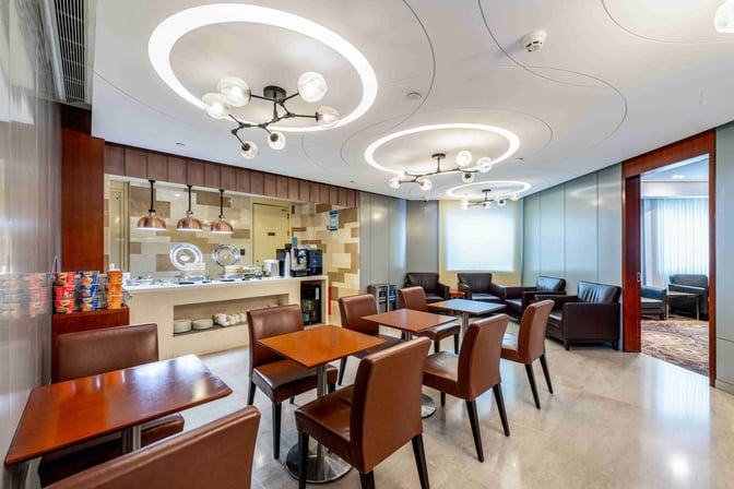 The lounge at Shanghai Hongqiao International Airport features a self-serve food area with seating and a coffee machine.