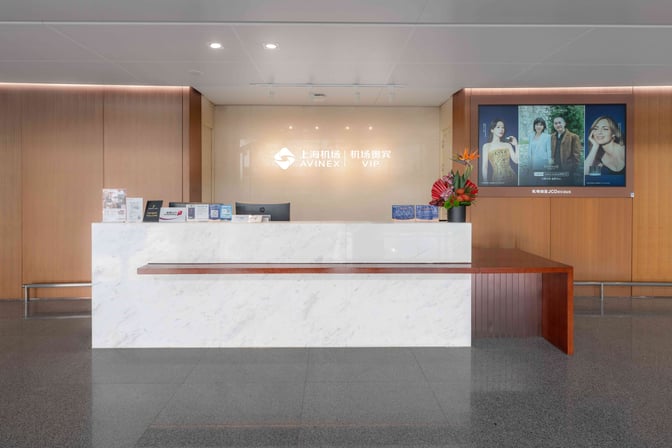 The reception area at Shanghai Hongqiao International Airport's Gate 6 features a check-in counter with informational brochures and a digital display.