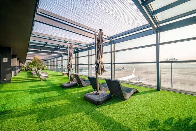 The 21-Metre-Level VIP Lounge at Shanghai Hongqiao International Airport features outdoor seating with views of the runway and artificial grass flooring.
