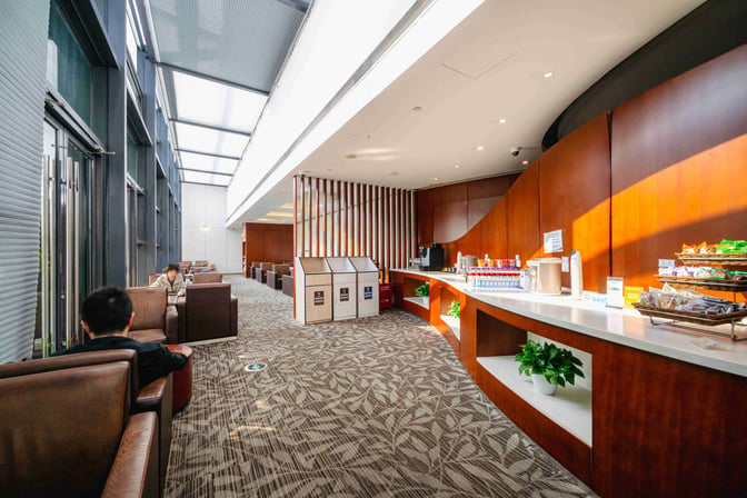 The 21-Metre-Level VIP Lounge at Shanghai Hongqiao International Airport features a self-serve snack and beverage counter with seating areas.