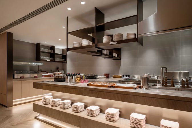 The Juneyao Air V6 VIP Lounge at Shanghai Hongqiao International Airport features a self-serve food area with various dishes and beverages.