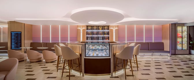The Juneyao Air V6 VIP Lounge at Shanghai Hongqiao International Airport features a central bar with seating and a display of beverages.