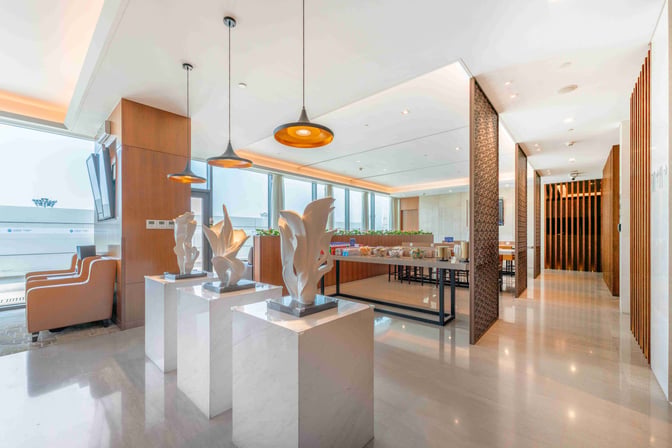 The VIP lounge at Shanghai Hongqiao International Airport features a seating area, decorative sculptures, and a self-serve food station.