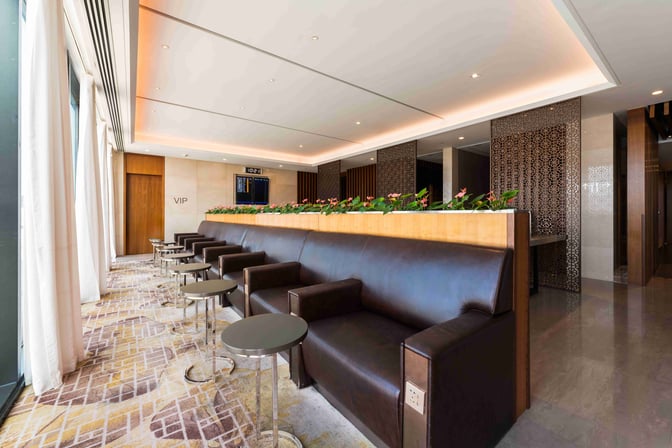 The VIP Lounge at Shanghai Hongqiao International Airport features comfortable seating with individual tables and a view of flight information displays.
