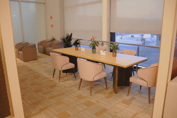 The Juneyao Air No 86 VIP Lounge at Shanghai Pudong features a dining table with seating and airport views.