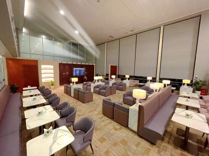 The Juneyao Air No 86 VIP Lounge at Shanghai Pudong International Airport features seating areas with tables and individual lamps.