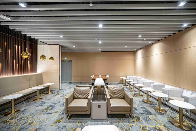 The seating area in No. 135 VIP Lounge at Shanghai Pudong International Airport features armchairs and tables arranged for comfort and convenience.