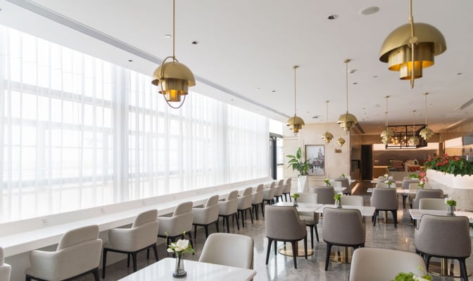 The No. 170 VIP Lounge at Shanghai Pudong International Airport features a spacious seating area with tables and chairs for dining.