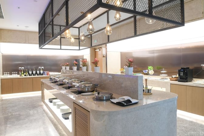 The No. 170 VIP Lounge at Shanghai Pudong International Airport features a self-serve buffet with hot dishes, beverages, and a coffee machine.