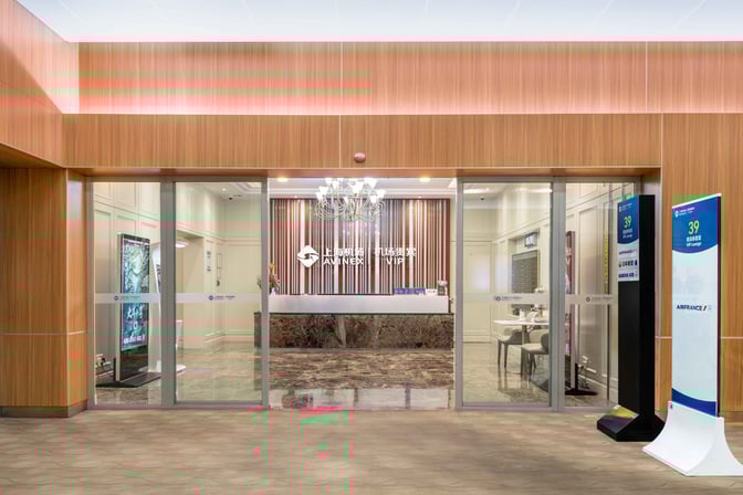 The entrance to the First Class Lounge at Shanghai Pudong International Airport features a reception desk and signage for Air France.